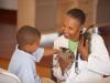 black female vet holding a kitten by a small young black boy
