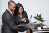 black man and woman holding a laptop and looking