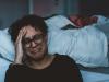person sitting on side of the bed and crying