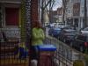 black woman sitting on porch and looking towards the street