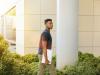 black man holding papers in hand while walking outside
