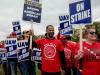 uaw strikers holding signs