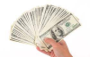 person holding a handful of 100 dollar bills
